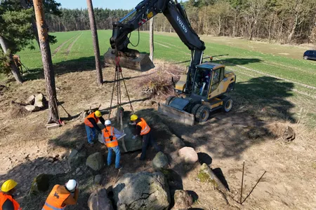 Volunteers and archaeologists rebuilt the tomb site, lifting massive stones with modern excavation tools.