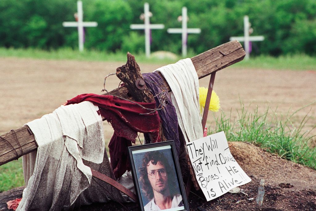 A photo of David Koresh rests beside a wooden cross