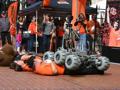 In the grand tradition of college marching band tomfoolery, the Oregon State University Mars Rover cuts a path over marching band members and the OSU mascot.