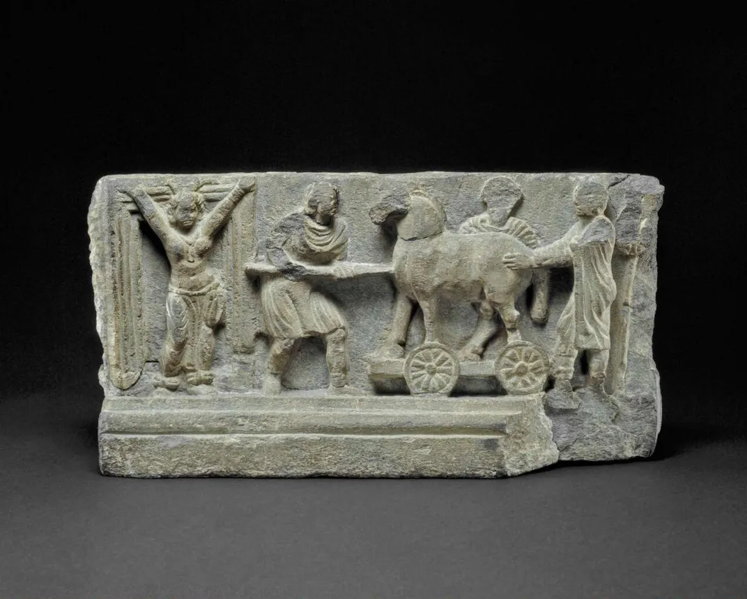 A relief carving from the Peshawar District of Pakistan that depicts a wooden horse being wheeled toward the gates of Troy and the prophetess Cassandra wailing in grief for the fate of her city