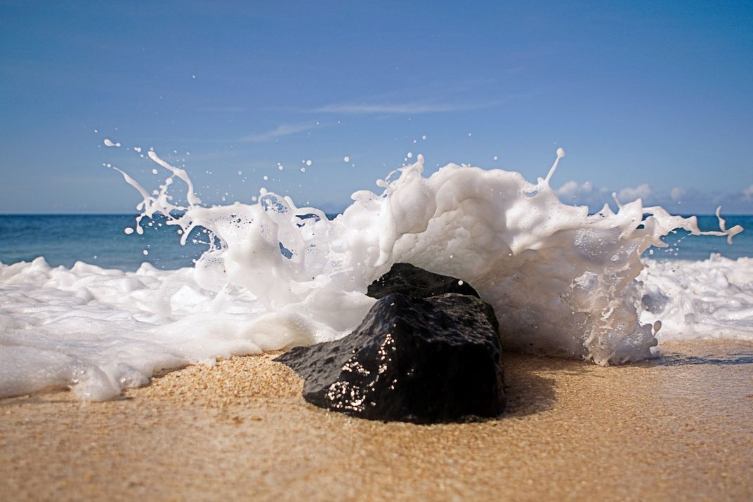 Ocean water splashes over a rock on the North Shore of Oahu, Hawaii
