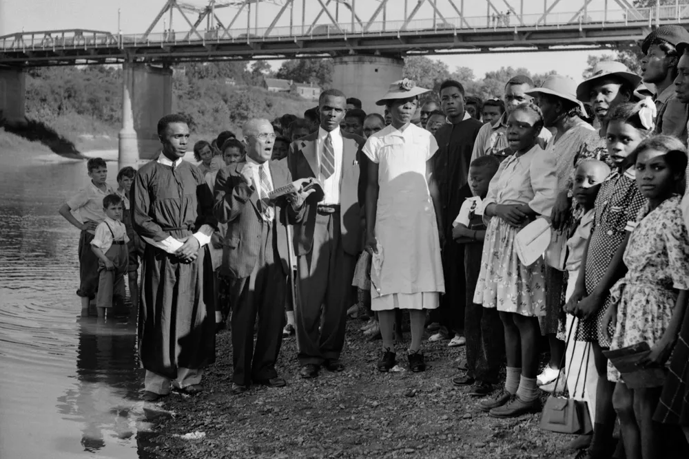A preacher with a baptismal group on the bank of the Tombigbee River, circa 1930s