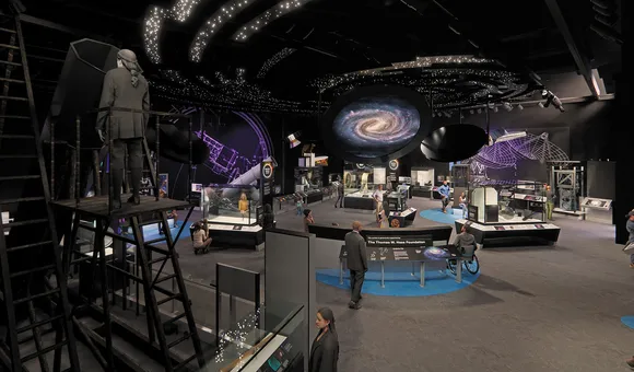 An artist's renderign of a cavernous museum exhibit space with a dark ceiling illuminated by images of bright white stars and a spiral galaxy. On the floor of the gallery, numerous visitors wander past glass display cases filled with artifacts.