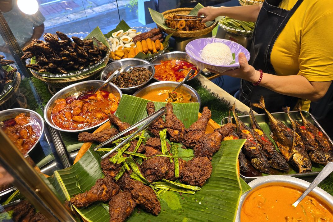 Traditional Malaysian Nasi Lemak, with rice, curries, chicken, and fish