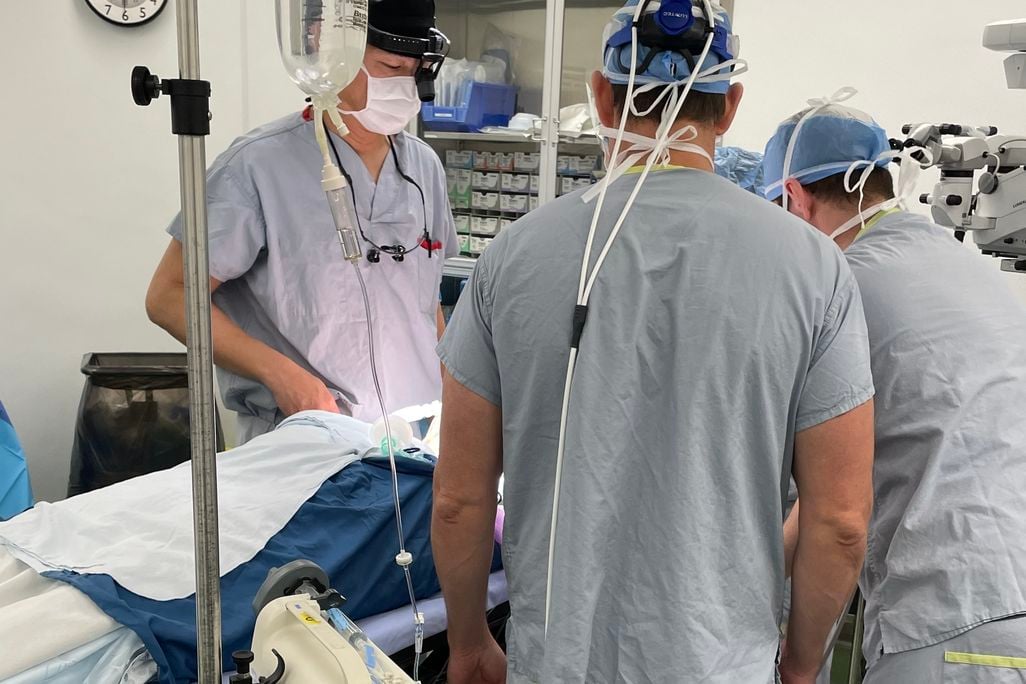 Surgeons standing over a patient in a hospital