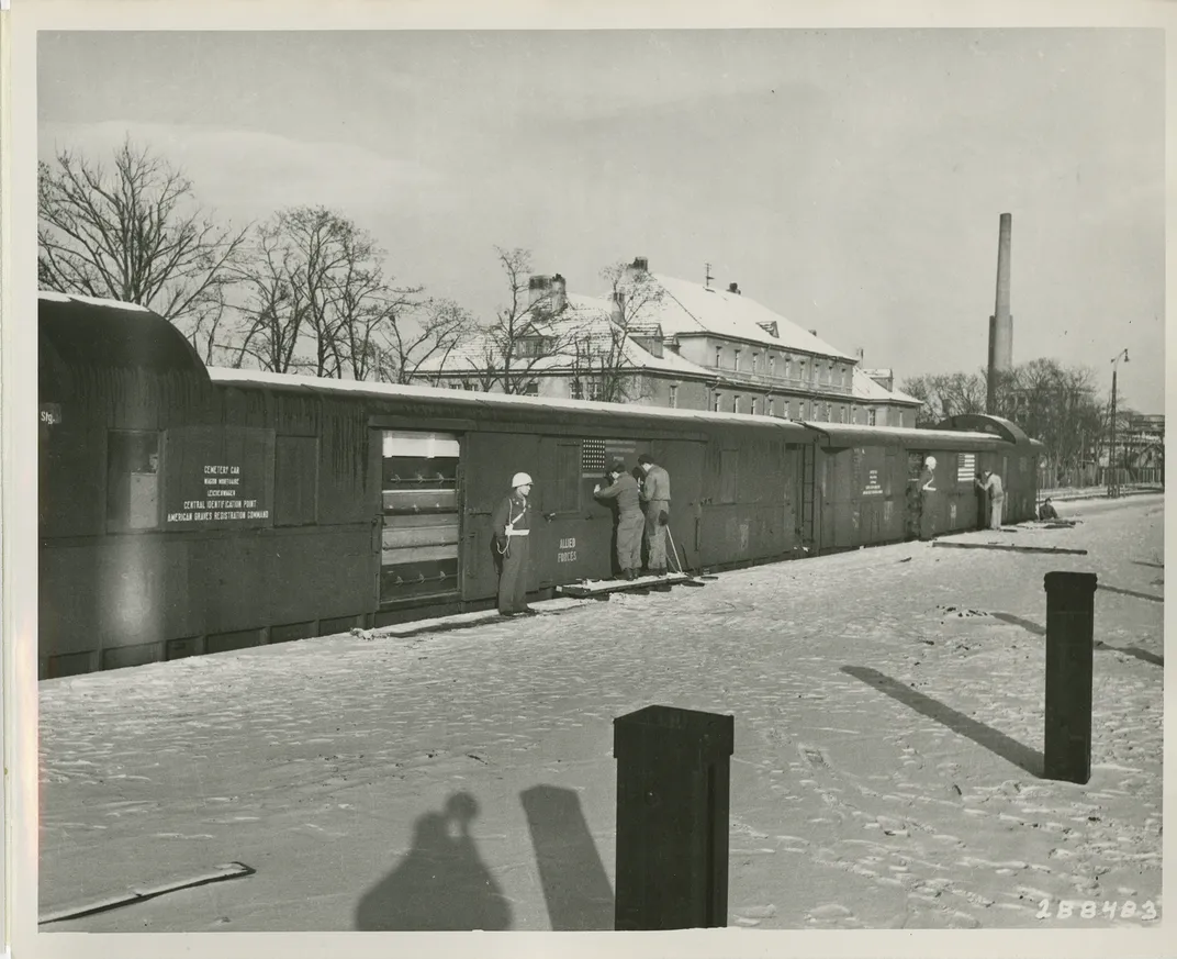 World War II dead are transported by rail from a central identification point in Germany to a temporary U.S. military cemetery in Belgium.