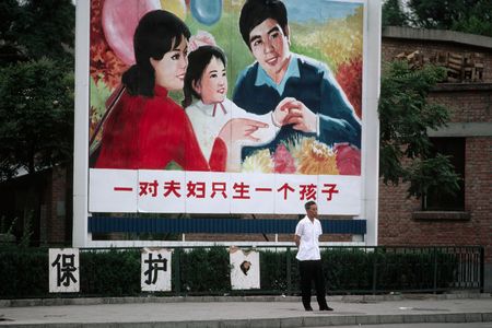 A man walks by a family planning billboard portraying parents and one child in Beijing in 1983. China just announced it will reverse its controversial one-child policy.