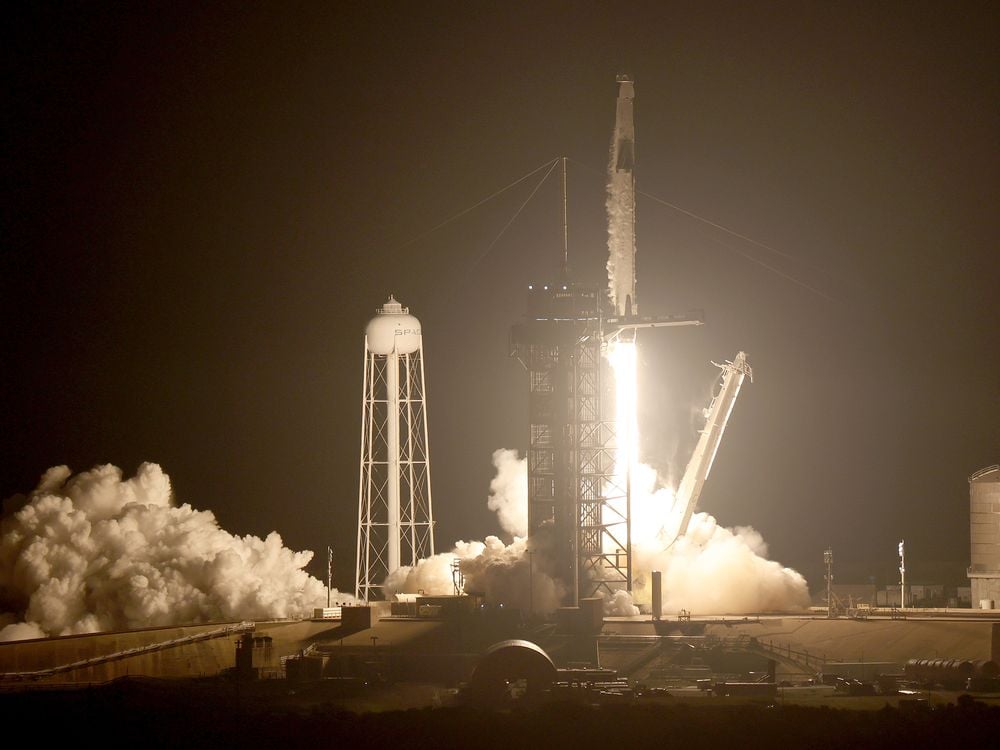 A rocket carrying a spacecraft with four astronauts launches against a night sky