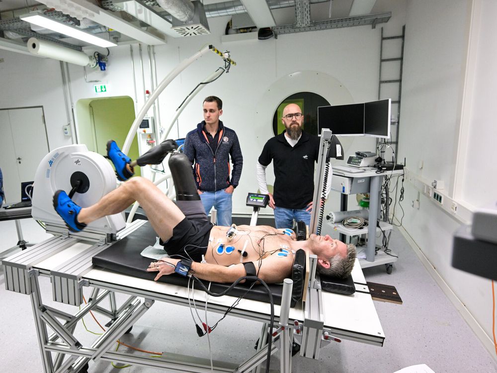man with prosthetic leg lies on a table pedaling a horizontal bike device