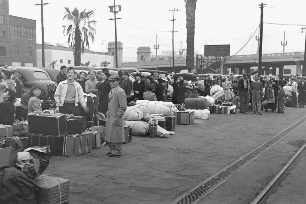 Japanese Americans wait for train to take them to Manzanar in 1942