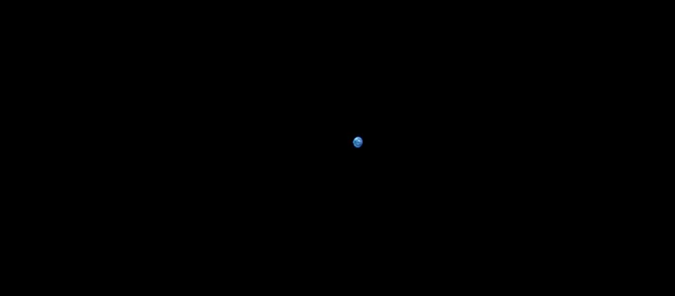 Earth appears as a small dot in the dark