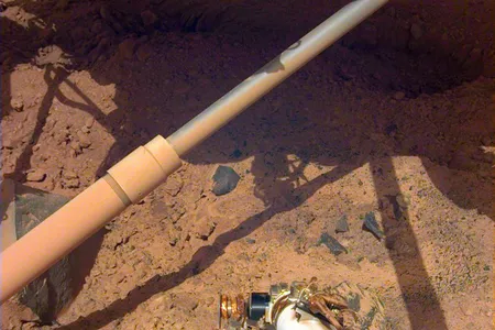 NASA's InSight lander peers down at the Martian surface. The mission recorded more than 1,300 quakes during its four years of operation.