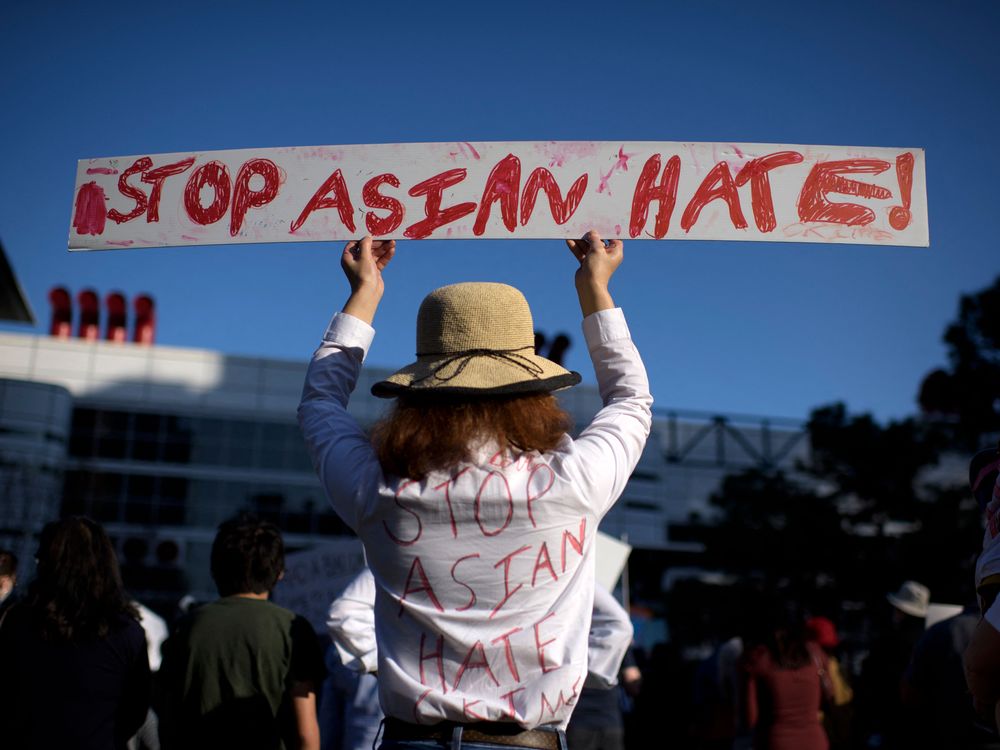 Woman holding sign that says Stop Asian Hate