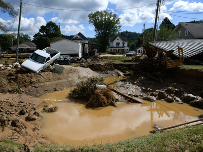 Debris is heaped on the banks of a river.