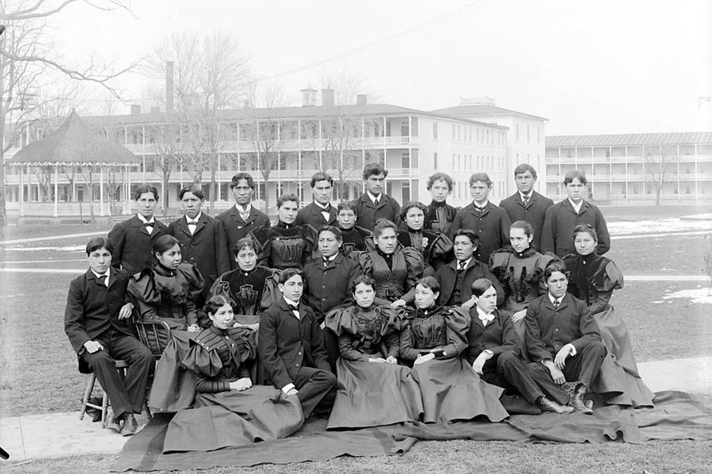 Group_of_Male_and_Female_Students;_Brick_Dormitories_And_Bandstand_in_Background_1879.jpg