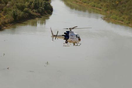 During a patrol of the border between the United States and Mexico, an Air and Marine Operations AS350 AStar helicopter flies low over the Rio Grande.