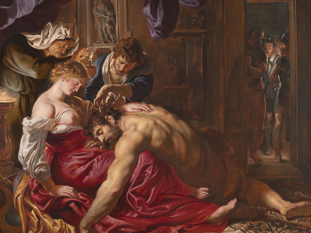 A large painting depicting a muscular Samson sprawled on the floor, resting his head in the lap of Delilah while someone else cuts some of his hair