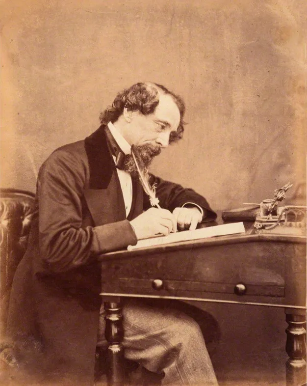 Charles Dickens, seen at his desk in 1858