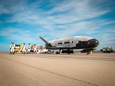 Pictures? No problem. But don’t expect much information. A crew tends to the X-37B after it landed at Vandenberg Air Force Base in October 2014, after 674 days in orbit. 