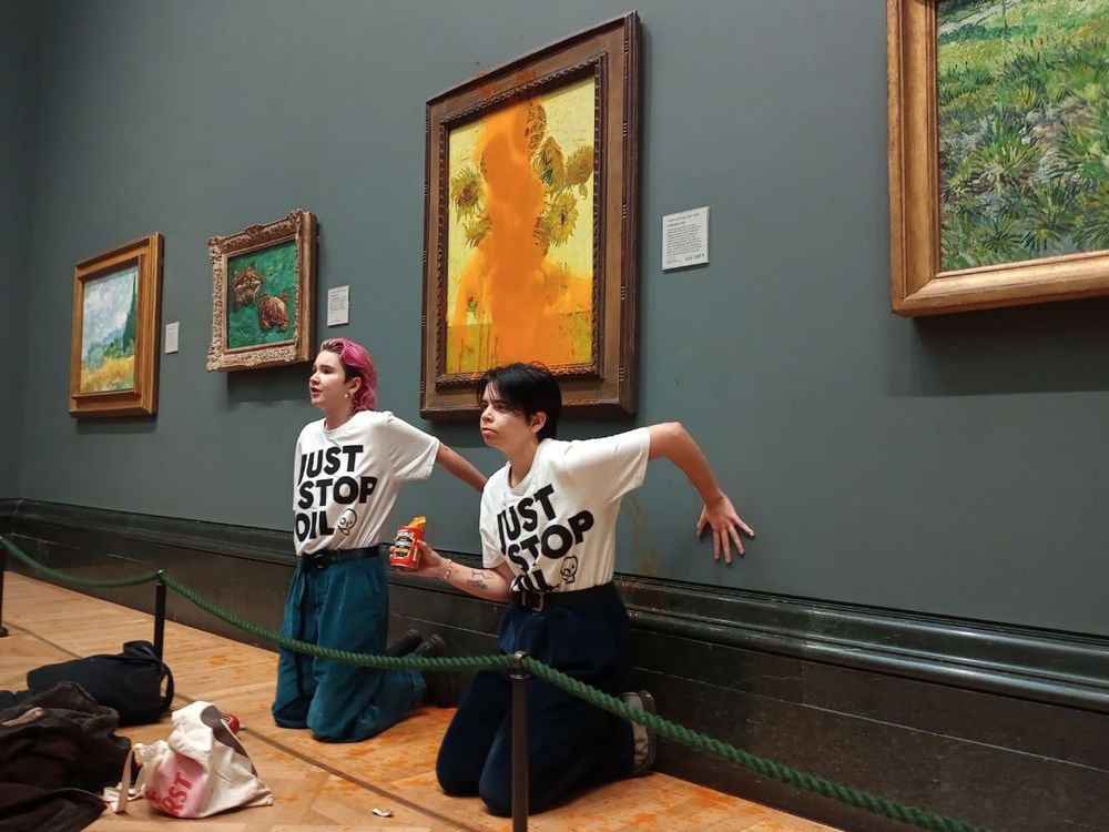 Climate protesters hold a demonstration as they throw cans of tomato soup at Vincent van Gogh's Sunflowers