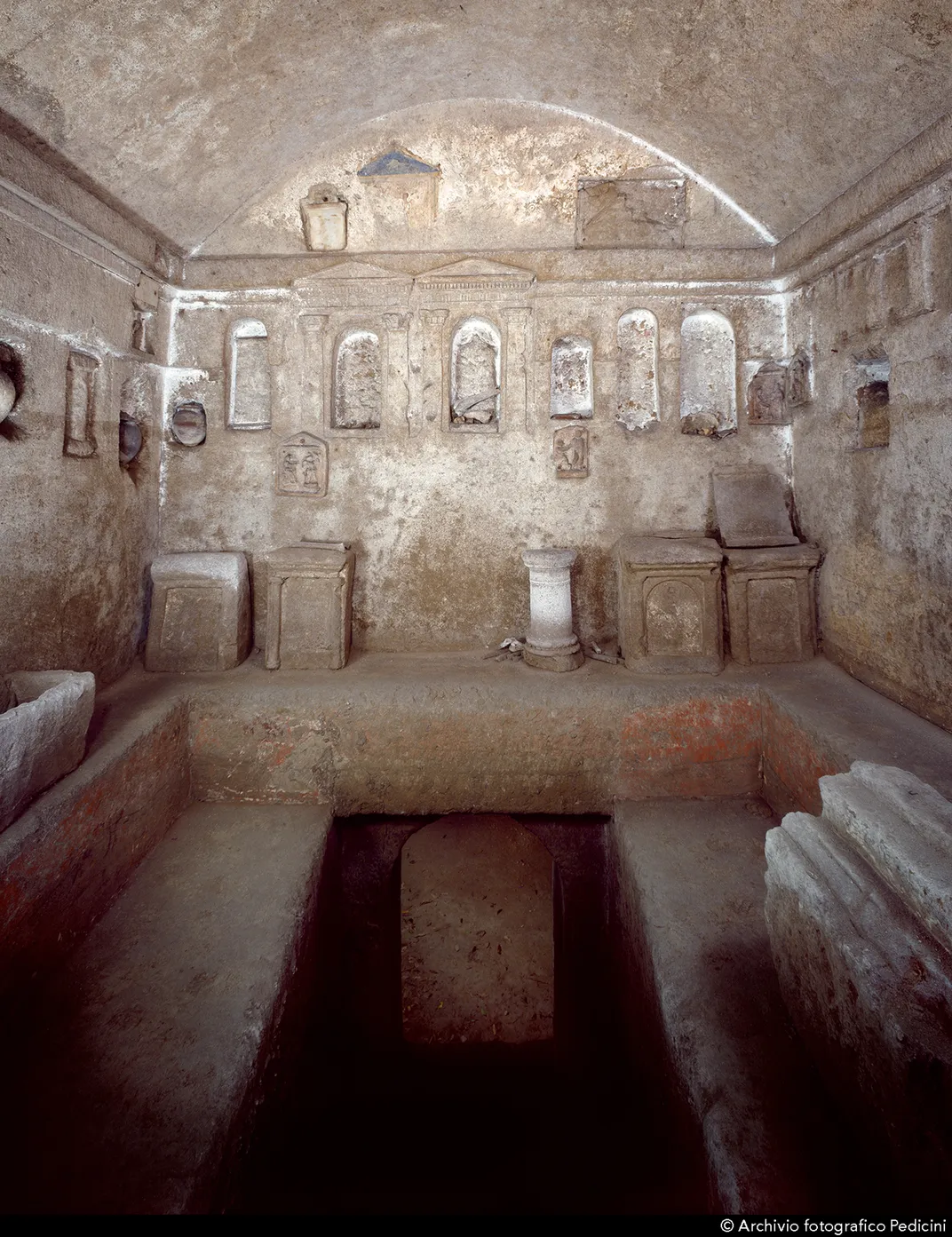 View of upper burial chamber, where funerary urns sit in niches above benches carved for mourners