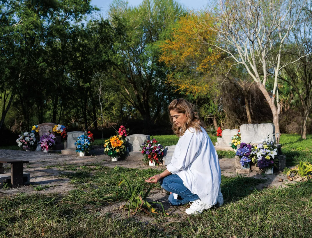 a women kneeling at a grave