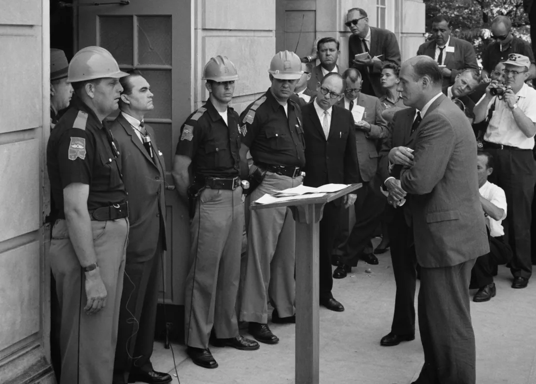 George Wallace (standing in door at left in a suit) refuses to allow two Black students to register at the University of Alabama in 1963.