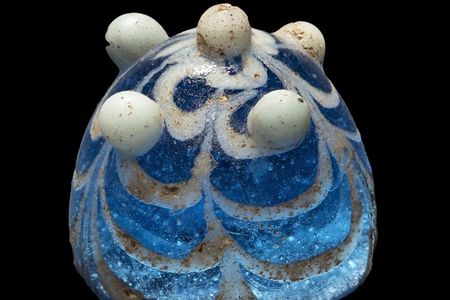 A piece of worked glass unearthed from the English island of Lindisfarne that researchers suspect may have once been a Viking game piece