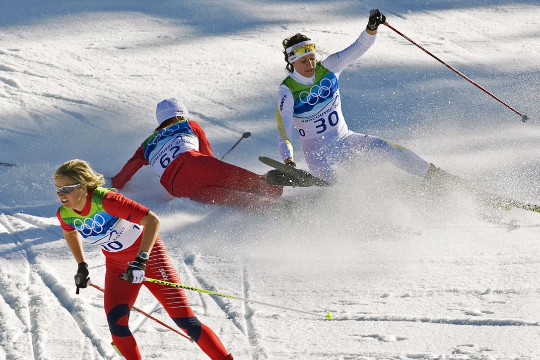 An Olympic cross country skier avoids a crash between two others.