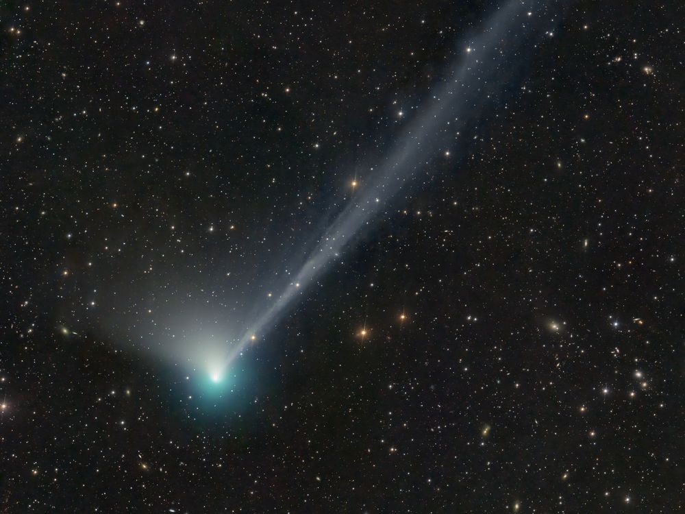 a green-blue comet against stars