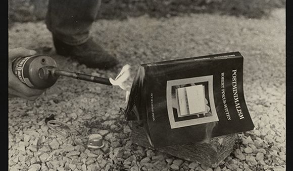 Lorna Truck and Tim Benson. Photograph documenting burning of Robert Pincus-Witten's book Postminimalism (1977) at the request of artist Buster Cleveland as part of the 1979 Des Moines Festival of the Avant-Garde, circa 1979. Fred Truck papers, 1965-2019. Archives of American Art, Smithsonian Institution.
