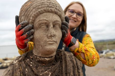 Archaeologist Rachel Wood holds a Roman bust found at the site of a Norman church.