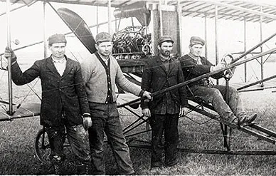 John, Joe, George, and Matt Savidge (from left) with one of their biplanes, ca. 1912.