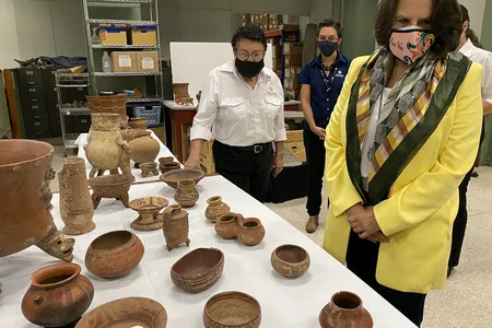Costa Rican Minister of Culture and Youth Sylvie Durán (right) examines some of the newly returned artifacts.