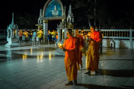 Monks lead a candlelight procession around the ordination hall during Vesak celebrations in rural Nakhon Nayok, Thailand.