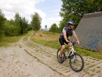 A cyclist rides his bicycle on the former border patrol road between East and West Germany.