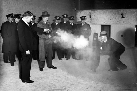 Lts. Frank Ballou and Samuel Peterson test out a new metal bulletproof shield. The shield's inventor, Elliot Wisbrod, is the man holding it. 