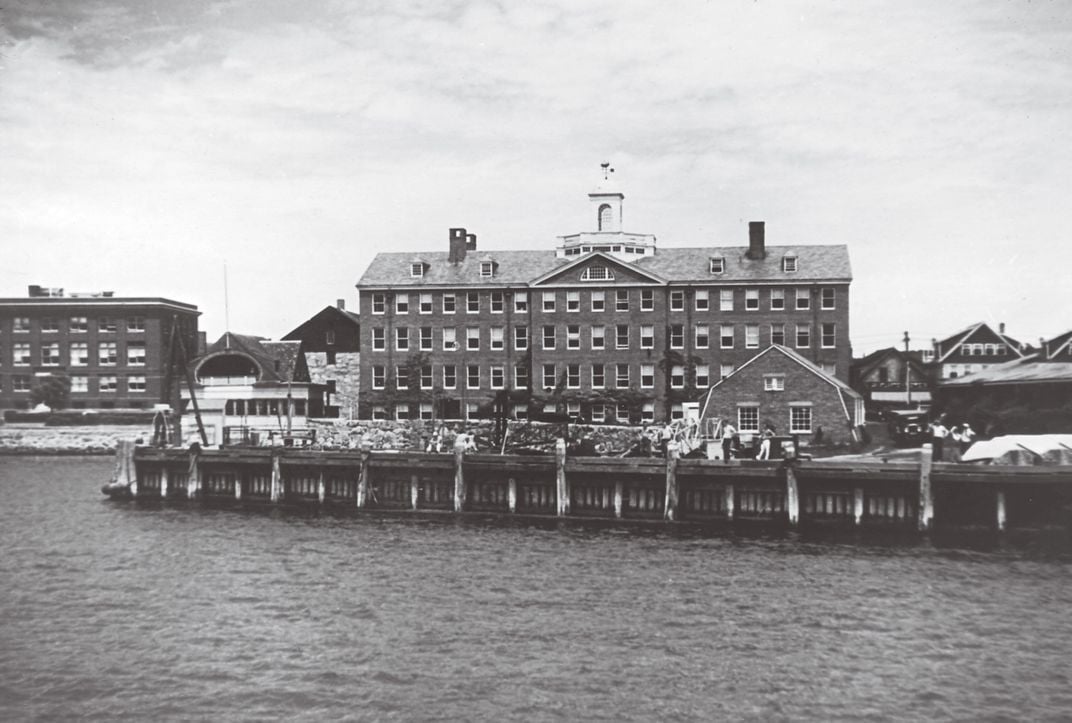 a brick academic building on the water.