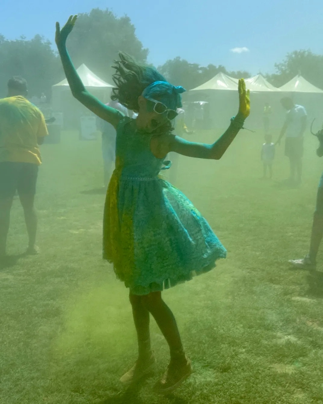a girl dances with colorful powder in the air