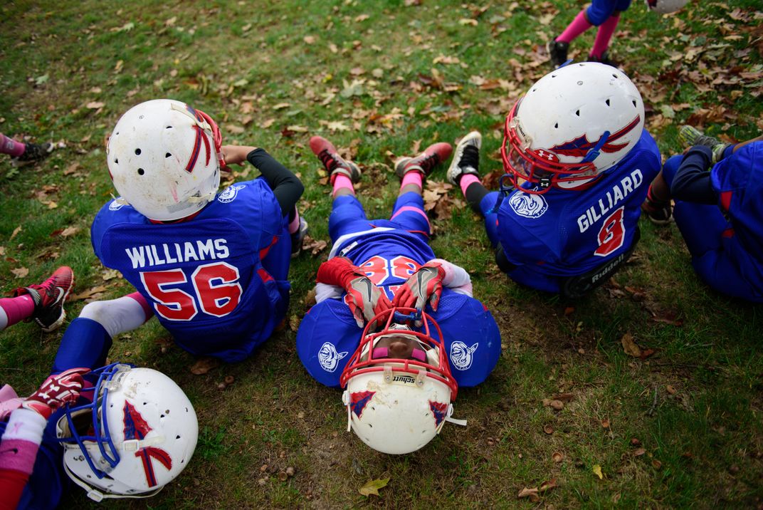 kids in blue football uniforms lay on the grass