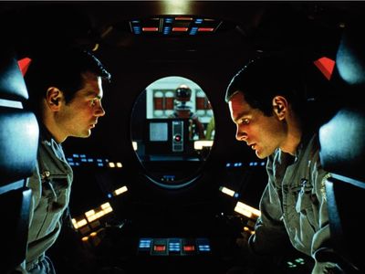 The astronauts of "2001: A Space Odyssey" hide in a pod to discuss the troubling behavior of their spacecraft's artificial intelligence, HAL 9000. In the background, HAL is able to read their lips.