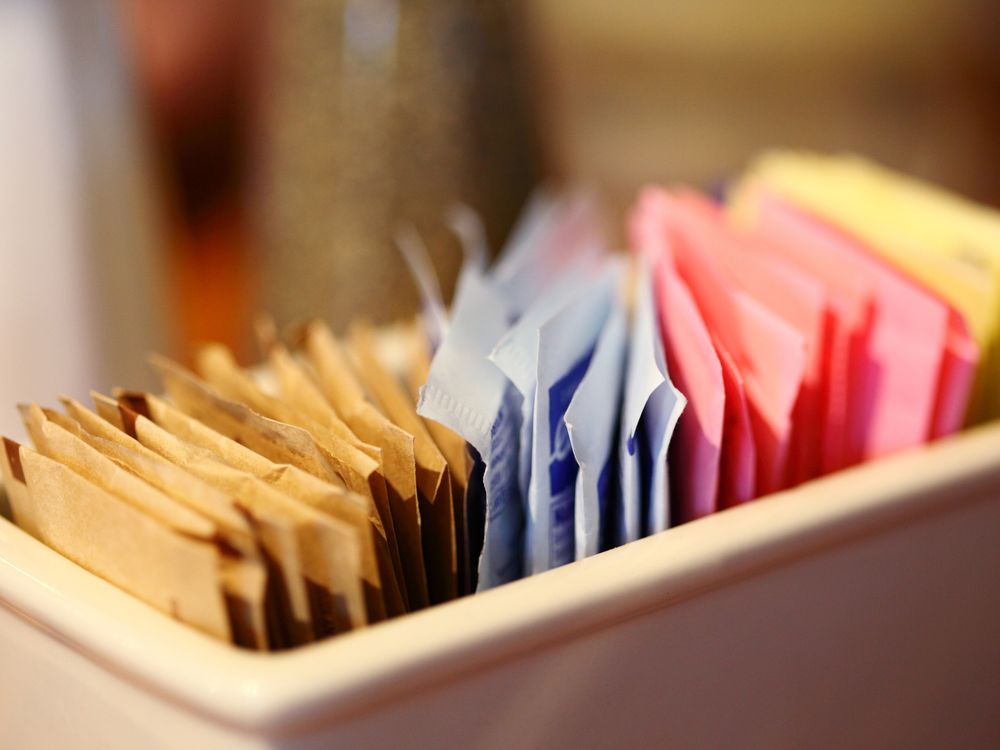A close-up of sweetener packets in a container