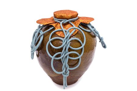 Chigusa, a tea jar, festooned with a traditional cover and ornamental cords.