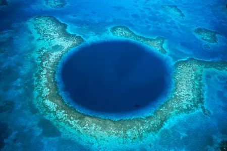 Belize's Lighthouse Reef Atoll surrounds the Blue Hole, a sunken cave system that is a haven for marine life and scuba divers.