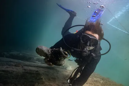 Archaeologist Gino Caspari holds an iron artifact recovered from one of the Menorca shipwrecks.