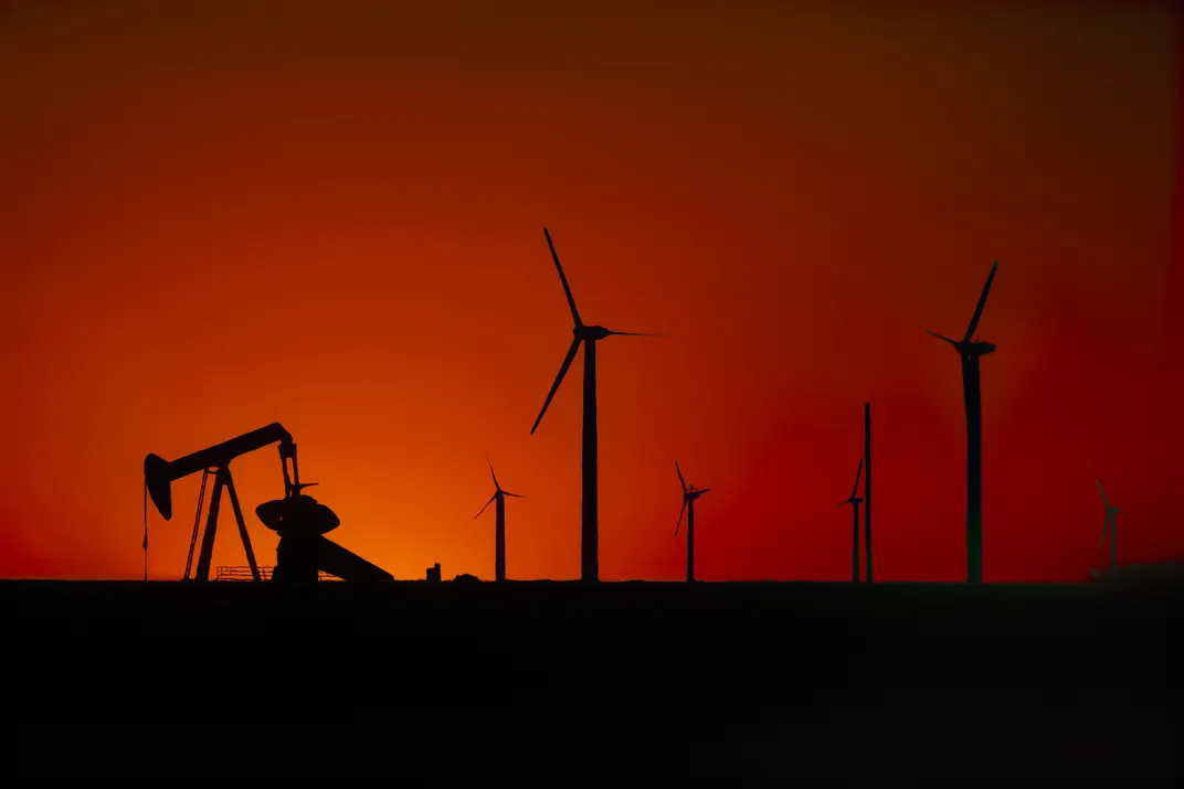 The sunset’s red afterglow silhouettes a landscape of oil and wind infrastructure outside Sweetwater.