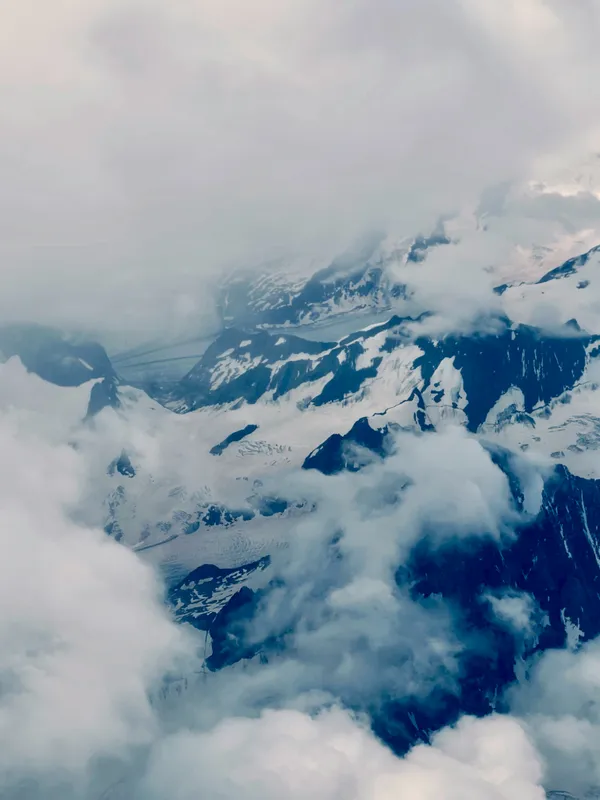 Snow tipped Italian alps covered with fog thumbnail