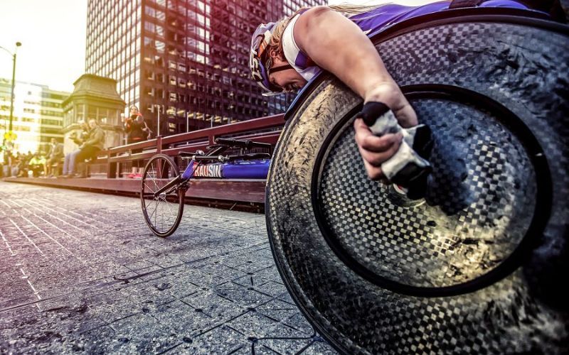 wheelchair racer races down city street