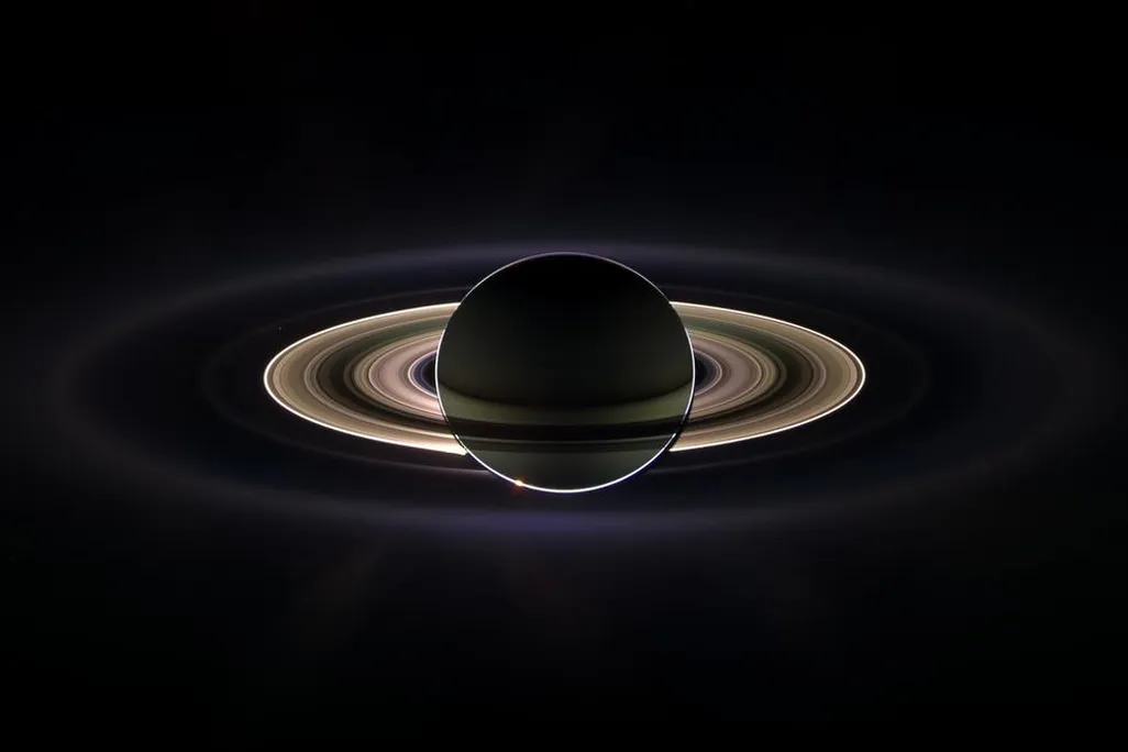 Saturn and its rings backlit