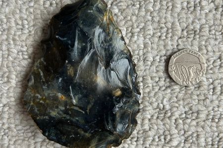 The hand ax, seen here beside a 20-pence coin, is between 40,000 and 60,000 years old.
